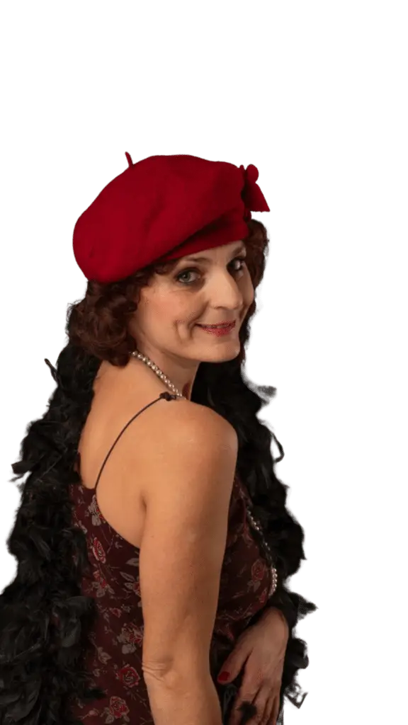 Alla Munchenbach in un costume di scena con un cappellino rosso che guarda lo schermo